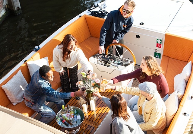 Open boat cruise with drinks people saying cheers having fun