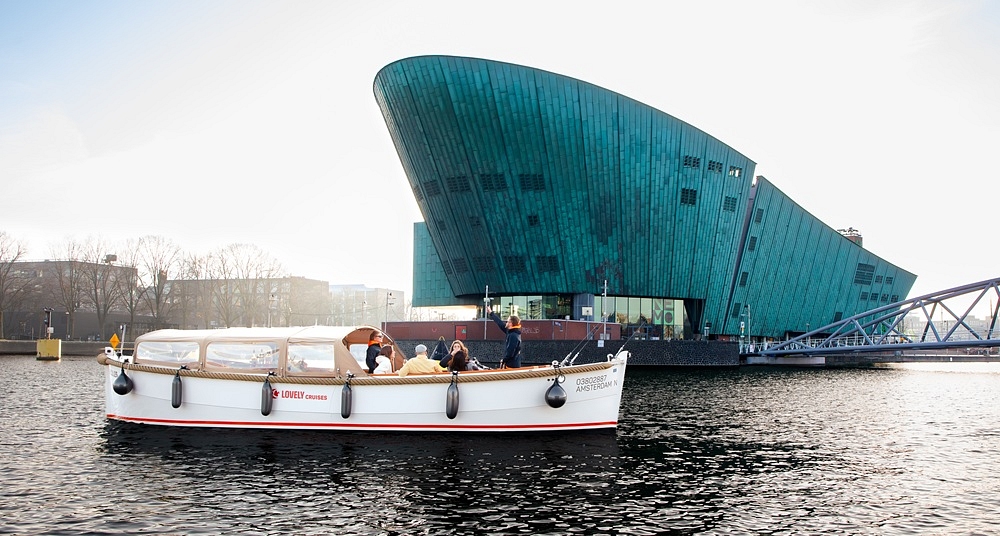 Lovely cruises about us open boat in front of NEMO Amsterdam